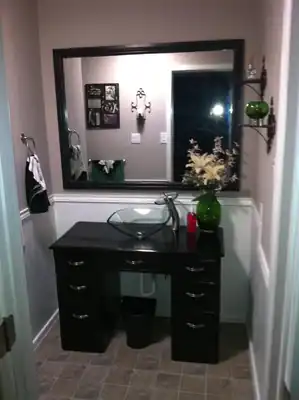 Powder room with vessel sink and painted vanity